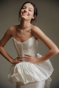 Woman wearing a white dress against a neutral background