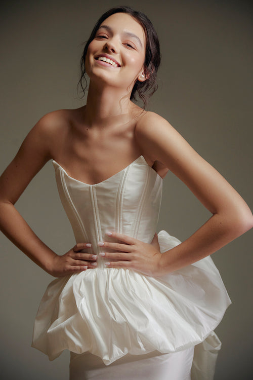 Woman wearing a white dress against a neutral background