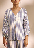 woman wearing a two piece striped blue and white  blouse and linen set gold buttons 